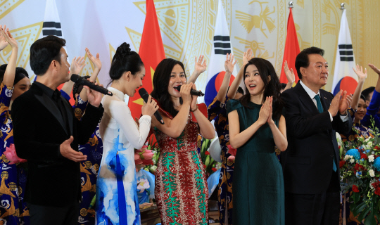 베트남을 국빈 방문 중인 윤석열 대통령과 김건희 여사가 23일(현지시간) 하노이 국제컨벤션센터에서 열린 국빈 만찬에서 축하 공연 출연진들을 격려하고 있다.연합뉴스